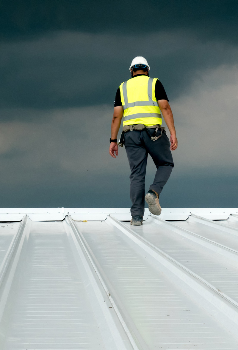 man standing on steel roof building
